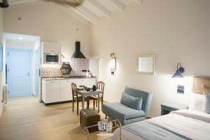 a room with a bed and a kitchen with a table and chairs at Morada de Mar apartamentos in Ribadesella