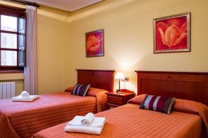 a hotel room with two beds with towels on them at Casa Rural Doña Manuela in Valdemierque