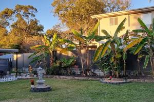 a yard with a fence and a house at The Heavenly Haven in Brisbane