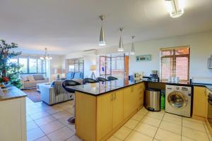 a kitchen with an island with a washing machine at Between The Milkwoods in Wilderness
