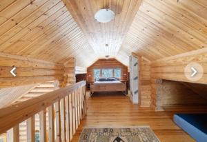 a log cabin bedroom with a bed and a wooden ceiling at LIHAPULLIA Lac, sauna, plage privée, deux chalets rien que pour vous in Nieminen