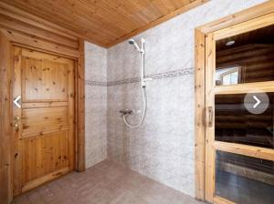 a bathroom with a shower and a wooden door at LIHAPULLIA Lac, sauna, plage privée, deux chalets rien que pour vous in Nieminen +21 photos