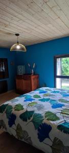 une chambre avec un lit avec un mur bleu dans l'établissement Chambre d'hôte, suite duplex 50 m2 en pleine nature sur les hauteurs de Brioude, à Champagnac-le-Vieux