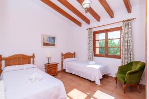a bedroom with two beds and a chair and a window at Villa Pedra Vista by Sealand Villas in El Port