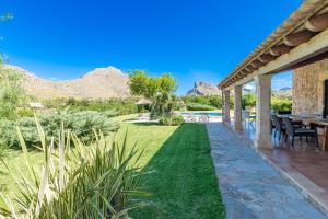 an outdoor patio with a table and chairs and a lawn at Villa Pedra Vista by Sealand Villas in El Port