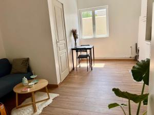 a living room with a couch and a table at Agréable T2, proche plage G in Rosendaël +9 photos