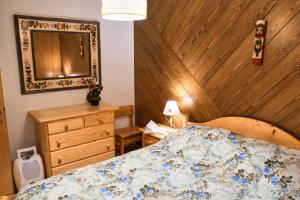 een slaapkamer met een bed en een houten wand bij Villa Antermont in Canazei