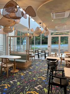 a restaurant with tables and chairs and windows at ibis Styles Pontivy centre Bretagne in Pontivy
