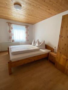 a bedroom with a large bed with a wooden ceiling at Ferienwohnung Bargehr Marion in Sankt Gallenkirch +75 photos