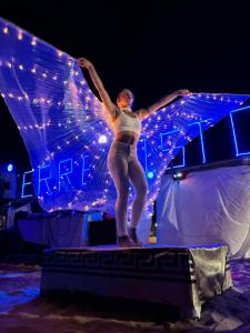 a woman standing on a stage with her arms in the air at Triscinamare Hotel Residence in Triscina +141 photos