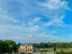 a building in a park with a blue sky at Pokoje na Bulwarach Samoobsługowe 24 I 7 in Suwałki