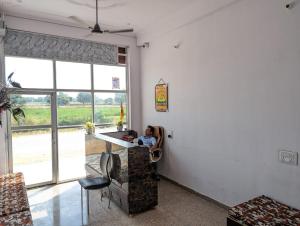 KhātuHotel Raghunath Palace的坐在房间柜台上的女人
