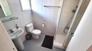 a bathroom with a toilet and a sink and a shower at Lovely 1BR in Old Town - City Center & 4min to Beach in Scala +14 photos