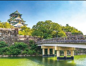 a bridge over a river with a castle in the background at OMOTENASHI STAY OSAKA 41m2 1LDK 十三駅徒歩1分 梅田2分 神戸京都アクセス良好 和室のある家 in Osaka