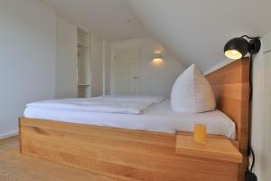 a bedroom with a bed with a glass of orange juice at Smutje, Ferienhaus in Groß Schwansee