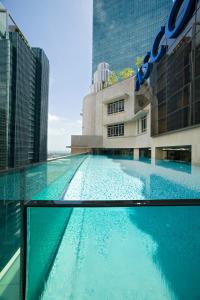 a large swimming pool in front of a building at Ascott Raffles Place Singapore in Singapore