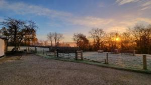 une ferme avec une clôture et des animaux dans un champ dans l'établissement Couples Retreat in Beautiful West Devon Countryside, à Broadwoodwidger