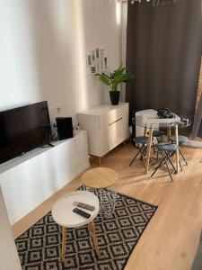 a living room with two tables and a flat screen tv at Complexe Cap Esterel village ,vue mer studio avec parking in Agay - Saint Raphael