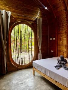 a room with a bed and a large window at The Backyard Inn in Moalboal