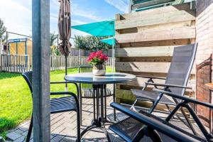 a patio with a table and chairs and an umbrella at Hello Zeeland - Apartment Noordstraat 30 in Zoutelande