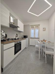 Home Ad Messinium في بومباي: مطبخ مع أجهزة بيضاء وطاولة مع كراسي