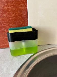 a green and black container sitting on top of a sink at 5 минут Астана Аэропорт in Prigorodnyy