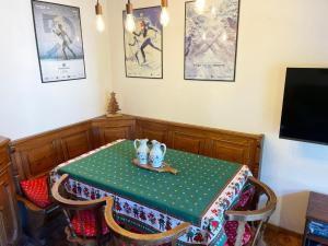 a table with a green table cloth and two cups on it at La Finestra sui Monti - Alpine Stay Apartments in Cavalese