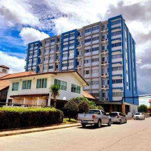 a large blue building with cars parked in front of it at Sport Villa Condo in Hua Hin