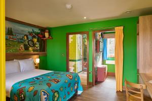 a green bedroom with a bed and a green wall at LEGOLAND(R) Windsor Resort in Windsor