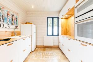 eine Küche mit weißen Schränken und einem Kühlschrank in der Unterkunft Maison avec terrasse au centre de Dolus d'Oléron in Dolus-d'Oléron + 7 Fotos