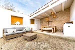 eine Terrasse mit einer Couch und einem Tisch in der Unterkunft Maison avec terrasse au centre de Dolus d'Oléron in Dolus-d'Oléron