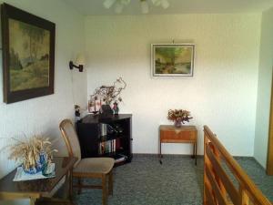 a living room with a table and a chair at Ferienwohnung Thomsen in Taarstedt