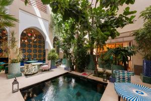 an indoor pool with chairs and trees in a building at Riad Due in Marrakesh