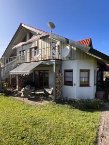 a white house with a balcony and a lawn at sHÄUSL - Bergblick, TV, WLAN in Weitnau