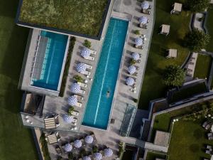 DAS EDELWEISS - Salzburg Mountain Resort في غروسارل: اطلالة علوية على مسبحين مع مظلات