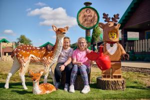 a man and a woman sitting next to a toy giraffe at LEGOLAND(R) Windsor Resort in Windsor
