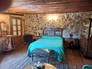 ein Schlafzimmer mit einem Bett und einer Steinwand in der Unterkunft Casa Rural Menta y Canela in Tórtoles