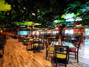 a dining room with tables and chairs and trees at LEGOLAND(R) Windsor Resort in Windsor