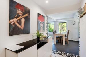Villa Eichwald Appartements في فرودنستاد: غرفة طعام بها لوحة لامرأة تلعب البيسبول