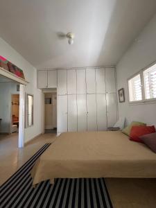 a bedroom with a large bed with white cabinets at Tel-Aviv Vibe Apartment in Tel Aviv
