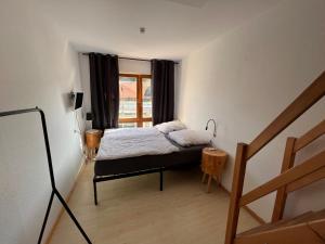 a bedroom with a bed in a room with a window at sHÄUSL - Bergblick, TV, WLAN in Weitnau