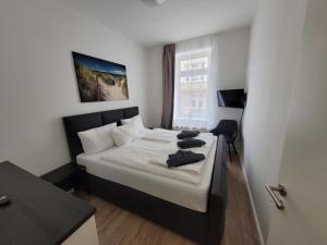 a bedroom with a bed and a desk and a window at Werder Appartements Rostock in Rostock