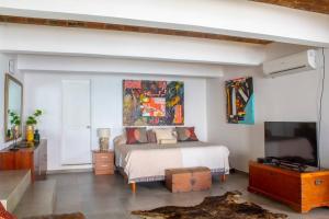 ein Schlafzimmer mit einem Bett und einem Flachbildfernseher in der Unterkunft Casa Las Doroteo in El Sunzal