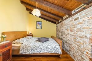 a bedroom with a bed and a brick wall at Villa Stari Dor in Heki +46 photos