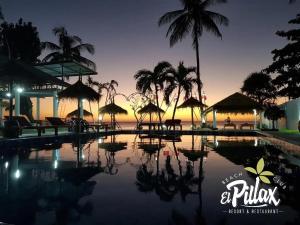 a swimming pool with umbrellas and the ocean at sunset at Villa - Sleeps 8 - Terrace - Beach Close in Ko Lanta