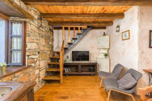 a living room with a staircase and a television at Villa Stari Dor in Heki