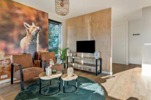 TV a/nebo společenská místnost v ubytování 'Lodge de Vos' luxe en vrijstaande lodge bij het Speulder- en Spielderbos