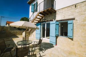 a patio with a table and chairs and an umbrella at Dipaton House in Vasa 1 in Limassol