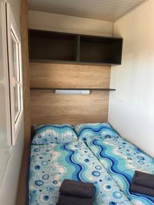 a bed in a small room with a painting on it at Mobile homes Tina Pakoštane in Pakoštane