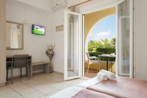 a bedroom with a door open to a balcony at Tereza Apartments in Acharavi